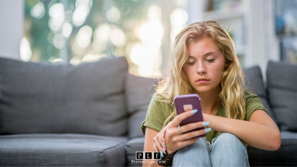 Blonde woman checking her enphase enlighten app while sun shines in the window behind her.